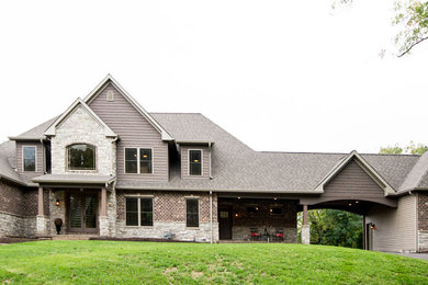 Large traditional two-storey brown house exterior in St Louis with a hip roof, a shingle roof and mixed siding.