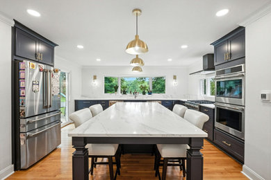 Enclosed kitchen - mid-sized transitional u-shaped light wood floor and brown floor enclosed kitchen idea in Other with an undermount sink, shaker cabinets, blue cabinets, quartzite countertops, white backsplash, ceramic backsplash, stainless steel appliances, an island and white countertops