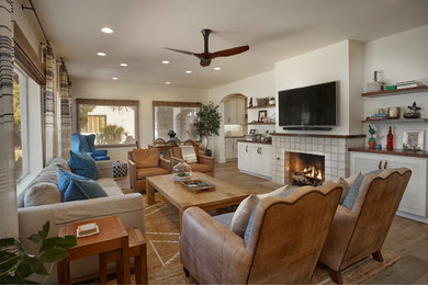 Living room - large traditional open concept light wood floor and brown floor living room idea in Other with white walls, a standard fireplace, a tile fireplace and a wall-mounted tv