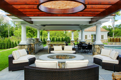 Example of a classic backyard custom-shaped infinity pool house design in New York