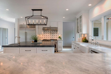 Inspiration for a large cottage u-shaped light wood floor and beige floor eat-in kitchen remodel in Santa Barbara with a farmhouse sink, white cabinets, marble countertops, gray backsplash, ceramic backsplash, stainless steel appliances and gray countertops