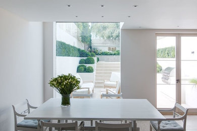 Contemporary dining room in London with white walls.