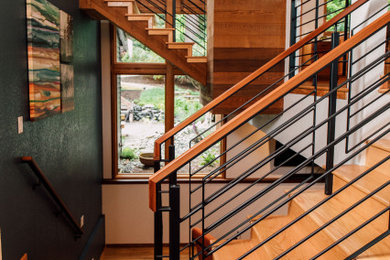 シアトルにある高級な中くらいなミッドセンチュリースタイルのおしゃれな折り返し階段 (木の蹴込み板、金属の手すり) の写真