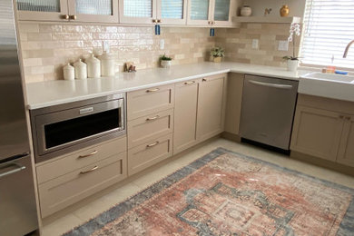 Example of a mid-sized classic u-shaped cement tile floor and beige floor enclosed kitchen design in Los Angeles with a farmhouse sink, shaker cabinets, brown cabinets, brown backsplash, ceramic backsplash, stainless steel appliances, no island and white countertops