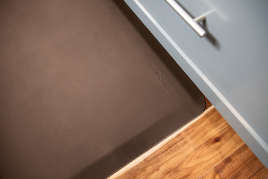 Küche mit grauen Schränken, braunem Holzboden und braunem Boden in Detroit