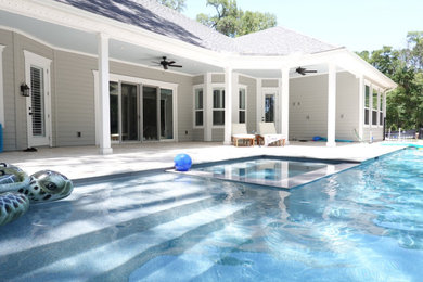 Large arts and crafts backyard stone and rectangular lap hot tub photo in Jacksonville