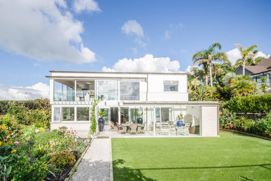 Example of a trendy white two-story mixed siding exterior home design in Auckland