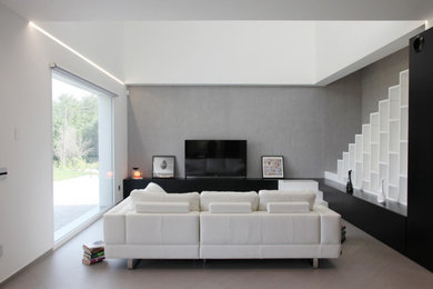 Idee per un soggiorno minimalista di medie dimensioni e aperto con libreria, pareti bianche, pavimento in gres porcellanato, TV a parete e pavimento grigio