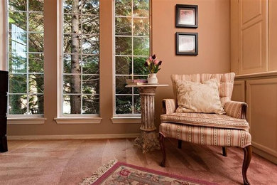 Example of an enclosed carpeted living room design in Vancouver with beige walls and no fireplace