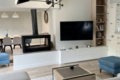 Exemple d'un salon tendance avec un mur beige, un sol en carrelage de céramique, une cheminée double-face et un téléviseur fixé au mur.