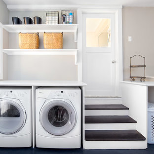 ボイシの大きいトランジショナルスタイルのおしゃれな洗濯室 (白いキャビネット、ラミネートカウンター、コンクリートの床、左右配置の洗濯機・乾燥機、オープンシェルフ、黒い床、白いキッチンカウンター、グレーの壁) の写真
