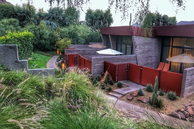 Large minimalist gray one-story brick exterior home photo in Phoenix with a metal roof