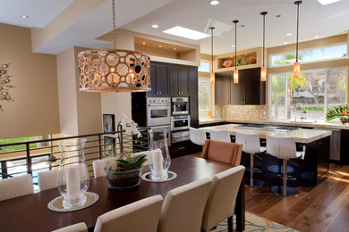 Example of a large trendy medium tone wood floor and brown floor kitchen/dining room combo design in San Diego with beige walls and no fireplace