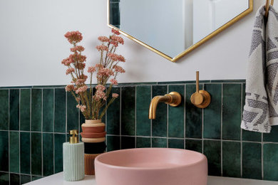 Toilet room - small 1950s green tile and ceramic tile ceramic tile, pink floor and single-sink toilet room idea in Orange County with light wood cabinets, a one-piece toilet, white walls, a vessel sink, quartzite countertops, a hinged shower door and white countertops