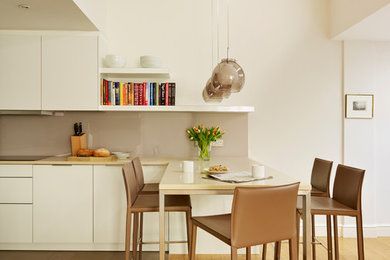 Design ideas for a medium sized contemporary dining room in London with beige walls, medium hardwood flooring and brown floors.