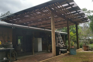 Photo of a mid-sized country backyard patio in Brisbane with brick pavers and a pergola.