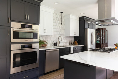 Eat-in kitchen - mid-sized transitional galley vinyl floor and brown floor eat-in kitchen idea in Other with an undermount sink, shaker cabinets, black cabinets, quartz countertops, white backsplash, stainless steel appliances, an island and white countertops