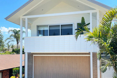 This is an example of a beach style attached two-car garage in Newcastle - Maitland.