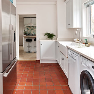 This is an example of a medium sized traditional separated utility room in Wiltshire with recessed-panel cabinets, white cabinets, terracotta flooring, a side by side washer and dryer and red floors.