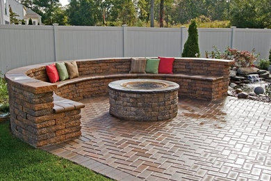 Example of a large classic backyard brick patio design in Orlando with a fire pit and no cover