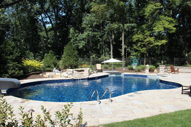 Design ideas for a large transitional backyard custom-shaped pool in Chicago with brick pavers and a water slide.
