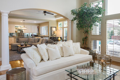 Inspiration for a large transitional open concept brown floor and medium tone wood floor living room remodel in Kansas City with beige walls, a standard fireplace and a stone fireplace