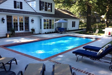 Design ideas for a mid-sized traditional backyard rectangular lap pool in Kansas City with brick pavers.