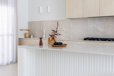 Exempel på ett stort skandinaviskt vit vitt kök, med släta luckor, skåp i ljust trä, bänkskiva i kvarts, beige stänkskydd, stänkskydd i porslinskakel, rostfria vitvaror, en köksö och beiget golv