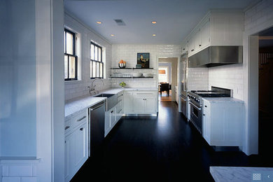 Inspiration for a contemporary galley painted wood floor enclosed kitchen remodel in Minneapolis with a farmhouse sink, recessed-panel cabinets, white cabinets, marble countertops, white backsplash, subway tile backsplash, stainless steel appliances and no island
