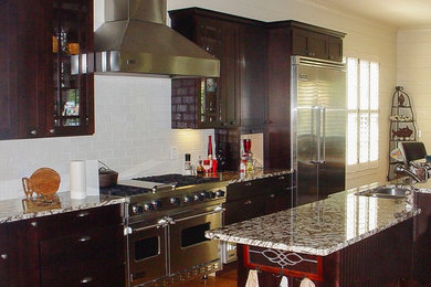 Example of a large trendy light wood floor eat-in kitchen design in Other with dark wood cabinets, granite countertops, a double-bowl sink, shaker cabinets, white backsplash, ceramic backsplash, stainless steel appliances and an island
