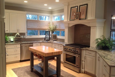 Mid-sized elegant u-shaped light wood floor and beige floor enclosed kitchen photo in Other with a double-bowl sink, raised-panel cabinets, white cabinets, brown backsplash, subway tile backsplash, stainless steel appliances, an island and gray countertops