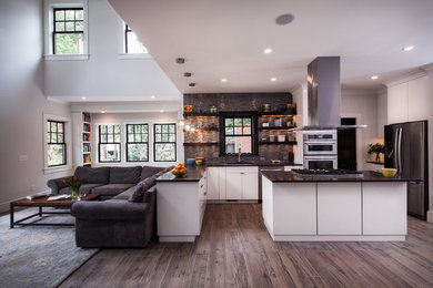 This is an example of a large transitional l-shaped open plan kitchen in Charlotte with an undermount sink, flat-panel cabinets, white cabinets, grey splashback, glass tile splashback, stainless steel appliances, medium hardwood floors and with island.