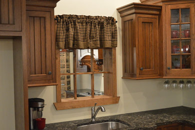 Large elegant l-shaped ceramic tile and beige floor eat-in kitchen photo in Philadelphia with an undermount sink, medium tone wood cabinets, quartz countertops, white backsplash, stainless steel appliances, an island and flat-panel cabinets