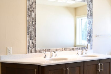 Example of a mid-sized classic master blue tile and subway tile laminate floor and gray floor bathroom design in Other with recessed-panel cabinets, brown cabinets, beige walls, an undermount sink, solid surface countertops and white countertops