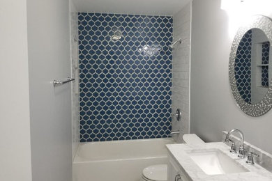 Mid-sized trendy master porcelain tile marble floor and multicolored floor bathroom photo in Chicago with a one-piece toilet, gray walls, an undermount sink and white countertops