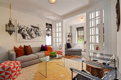 Mid-sized eclectic enclosed medium tone wood floor and brown floor living room photo in New York with white walls, no fireplace and no tv