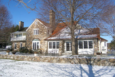 Traditional two-storey exterior in Philadelphia with stone veneer and a gable roof.