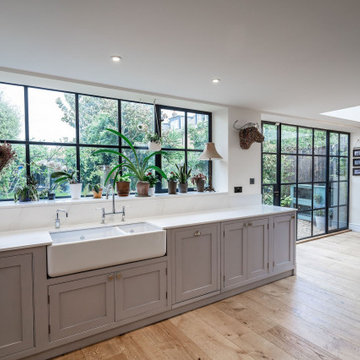 Hand painted grey kitchen with fridge surround and mirrored splash back