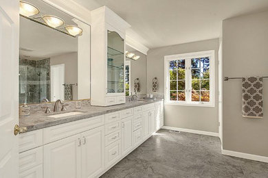 Photo of a traditional bathroom in Seattle with raised-panel cabinets, white cabinets, gray tile, stone tile and grey walls.