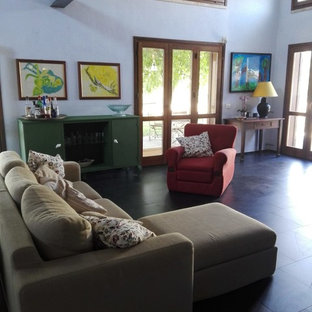 Esempio di un grande soggiorno mediterraneo aperto con pareti bianche, pavimento in ardesia, TV a parete e pavimento nero