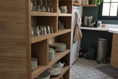 Inspiration pour une petite cuisine design en L et bois clair avec un placard à porte affleurante et une crédence verte.