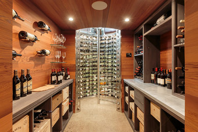 This is an example of a mid-sized contemporary wine cellar in New York with concrete floors, display racks and grey floor.