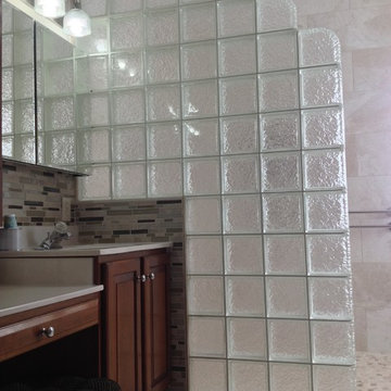 Step down glass block shower wall in an Icescapes pattern wih cherry cabinets Co