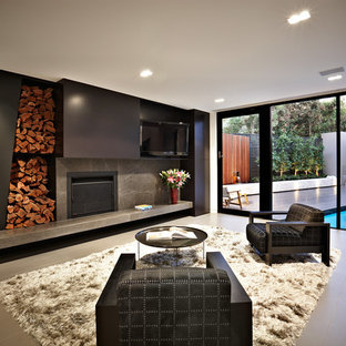Inredning av ett modernt vardagsrum, med svarta väggar, en standard öppen spis och en väggmonterad TV