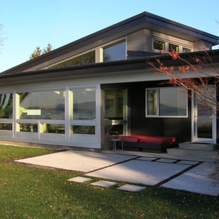 Создайте стильный интерьер: большой, двухэтажный фасад дома серого цвета в современном стиле с комбинированной облицовкой и полувальмовой крышей - последний тренд