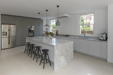 Inspiration for a large contemporary l-shaped ceramic tile and gray floor eat-in kitchen remodel in London with an undermount sink, flat-panel cabinets, gray cabinets, quartzite countertops, stainless steel appliances and an island