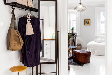 Mid-sized scandinavian entryway in Gothenburg with white walls, painted wood floors and white floor.