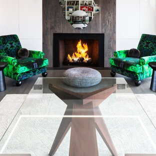 Diseño de despacho moderno, grande, con paredes blancas, suelo de madera oscura, chimenea tradicional, marco de chimenea de madera, escritorio independiente y suelo gris