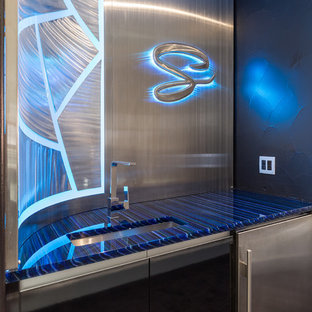 ダラスの小さいコンテンポラリースタイルのおしゃれなウェットバー (アンダーカウンターシンク、フラットパネル扉のキャビネット、黒いキャビネット、ガラスカウンター、グレーのキッチンパネル、メタルタイルのキッチンパネル、青いキッチンカウンター) の写真