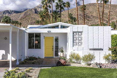 1960s white one-story stucco exterior home idea in Other with a white roof